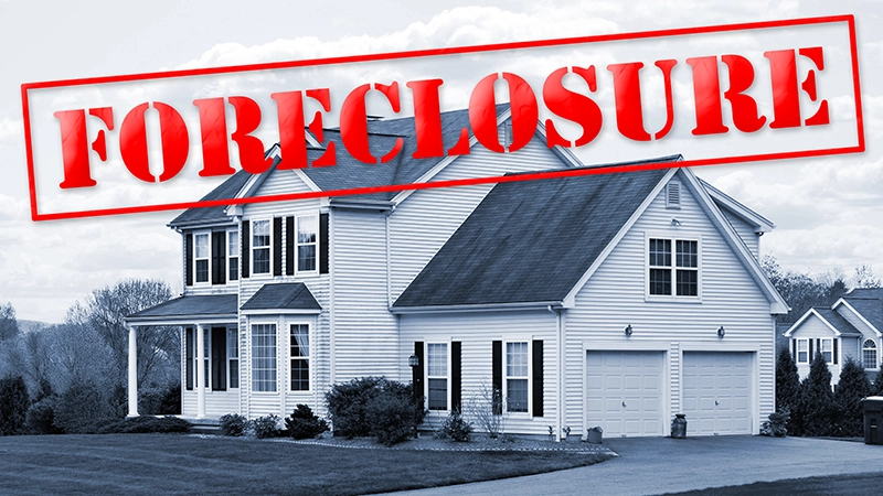 A foreclosed house with a red foreclosure stamp running along the top of the picture.