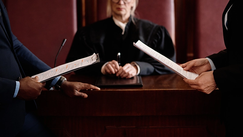 Close-up of prosecution and defense sides holding juridical documents.