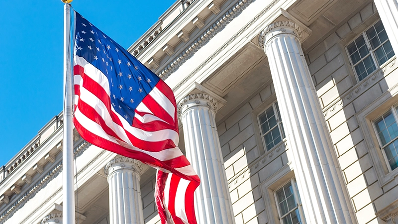 An American flag fluttering in the wind under a blue sky outside the Supreme Court .