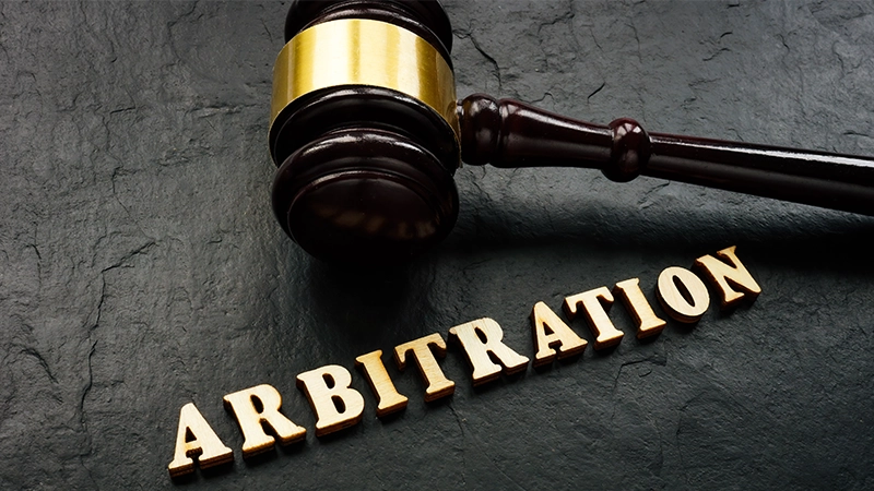 Arbitration word from wooden letters and gavel in court.