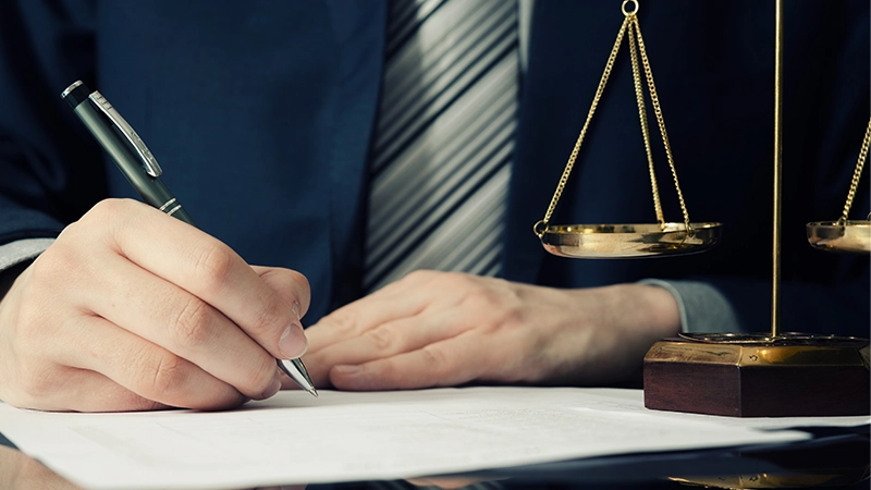 Lawyer working and signing agreement in office.