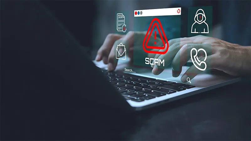 A business person using laptop with visual screen Scam Alert warning sign for scams with icon.